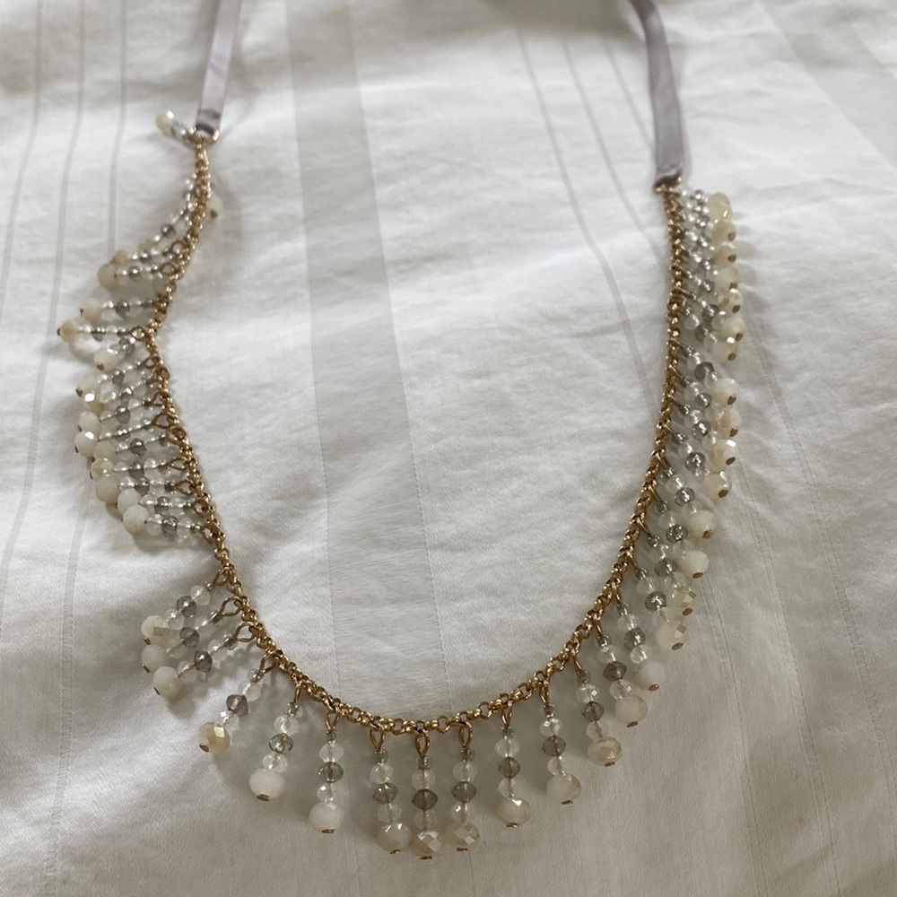 Beaded gold necklace with platinum satin ribbon closure.